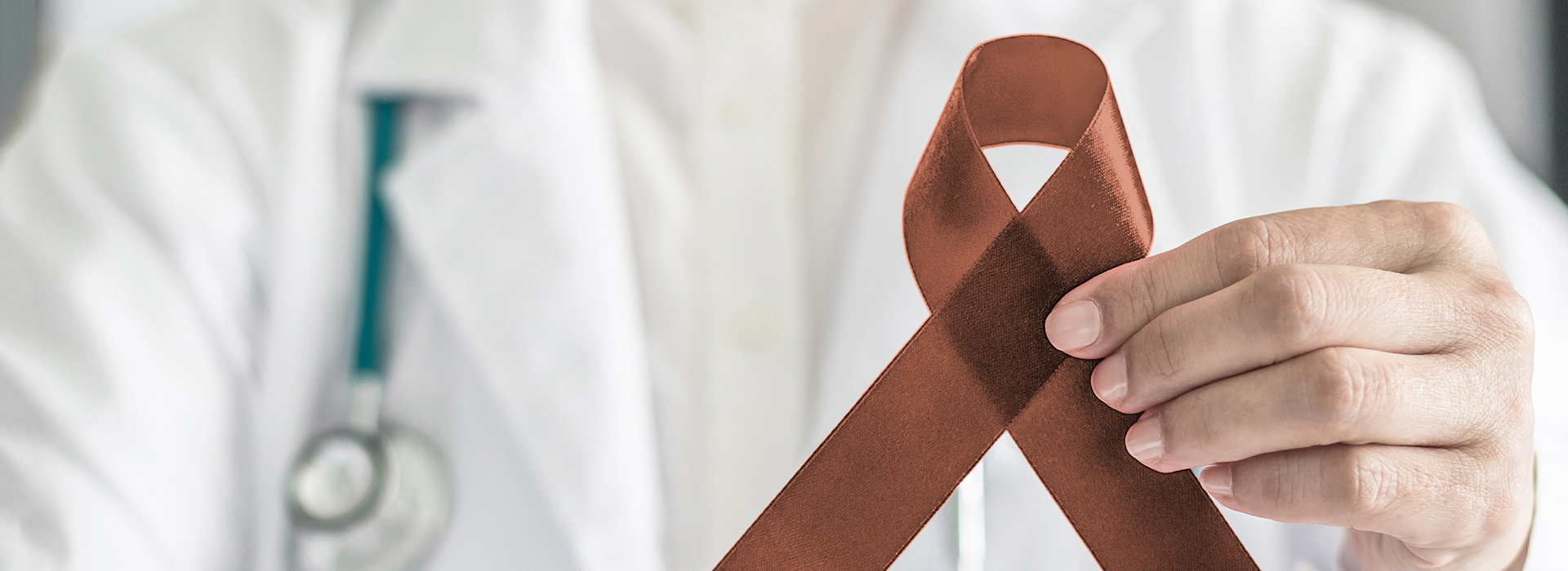 The image features a medical professional holding up a red ribbon, symbolizing awareness for a specific health issue or cause.