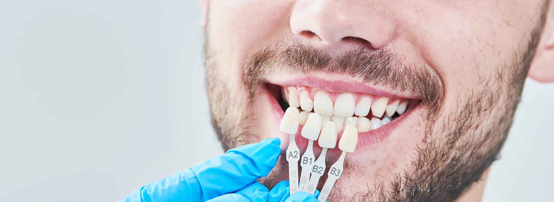 The image shows a close-up of a person with an open mouth, wearing a dental appliance and having their teeth cleaned by a dental professional.